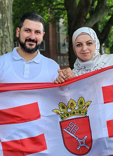 Abdelnasser und Hanin Alkourdi halten eine Speckflagge