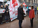 Lars Hartwig spricht mit Ute Reimers-Bruns; im Hintergrund Teilnehmer:innen der Protestaktion mit Fahnen und Transparenten